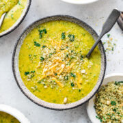 overhead view of vegan broccoli cheddar soup in a bowl with breadcrumb topping.