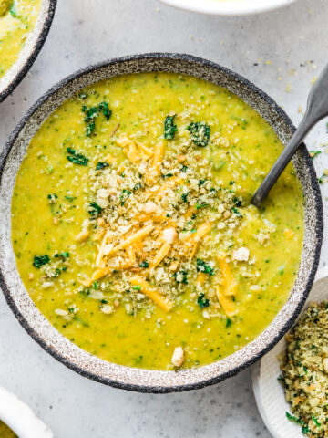 overhead view of vegan broccoli cheddar soup in a bowl with breadcrumb topping.