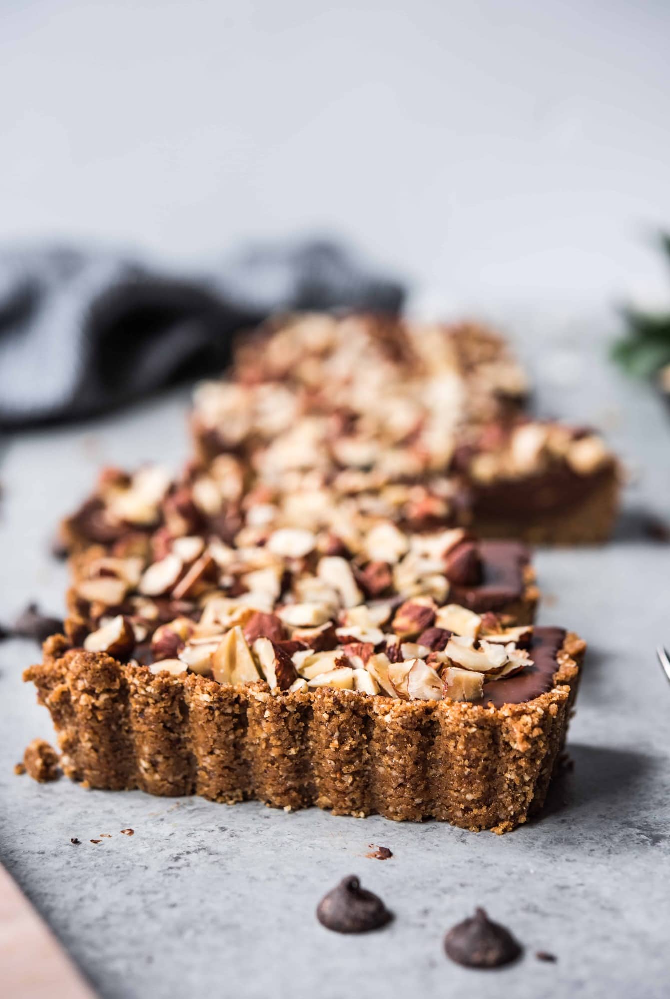 Side view of chocolate hazelnut tart with graham cracker crust