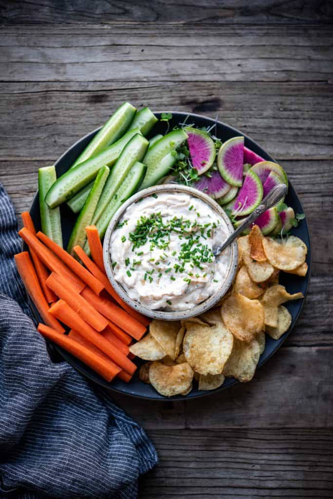 Overhead of vegan caramelized onion dip with vegetables on wood table