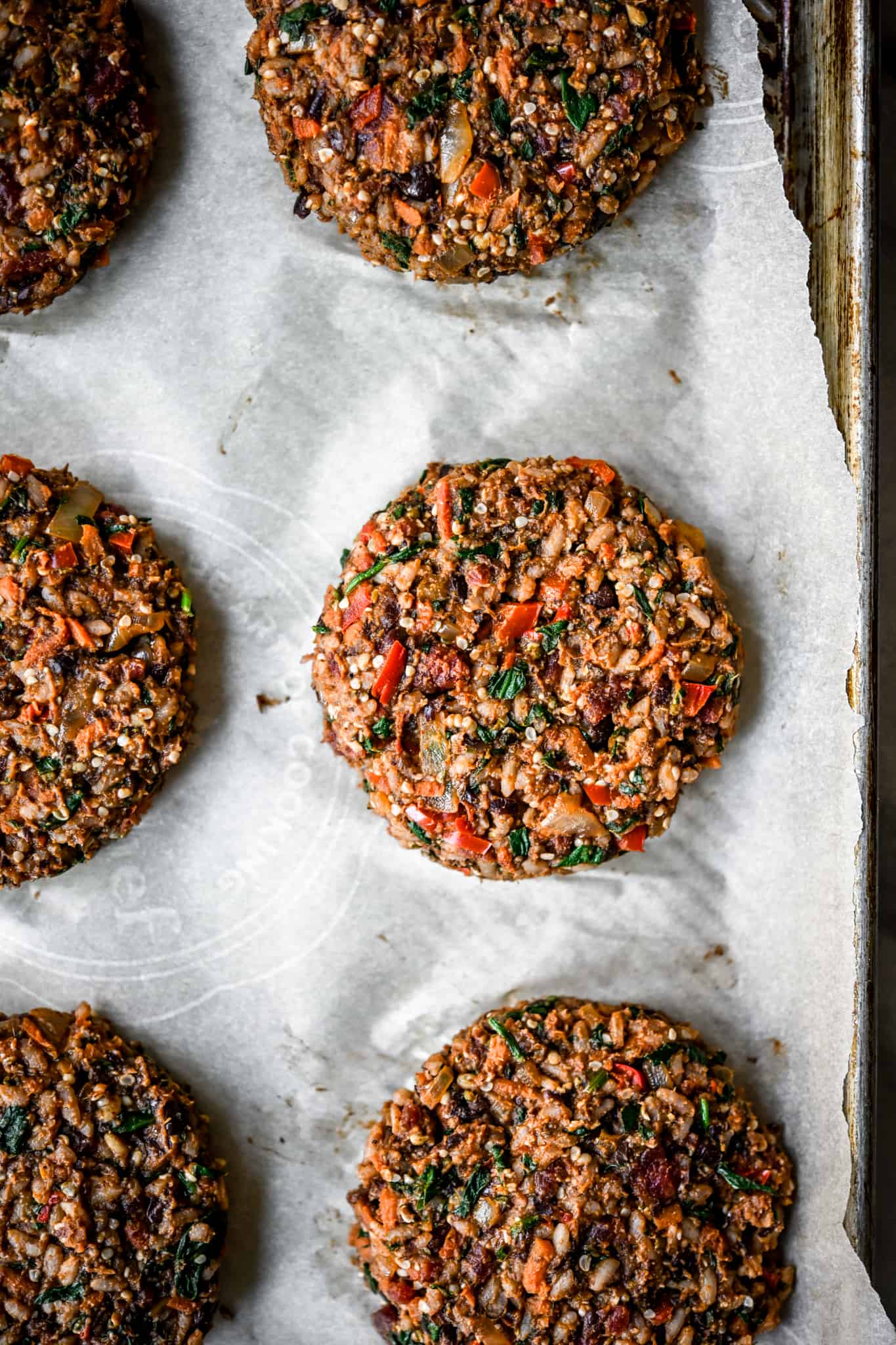 Uncooked veggie burger patties on a sheet pan