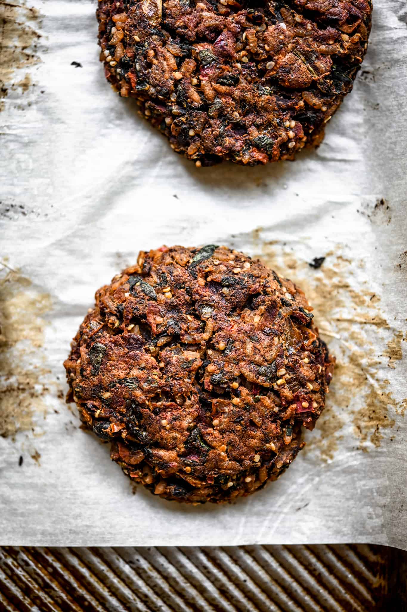 Overhead view of a cooked veggie burger patty on a sheet pan