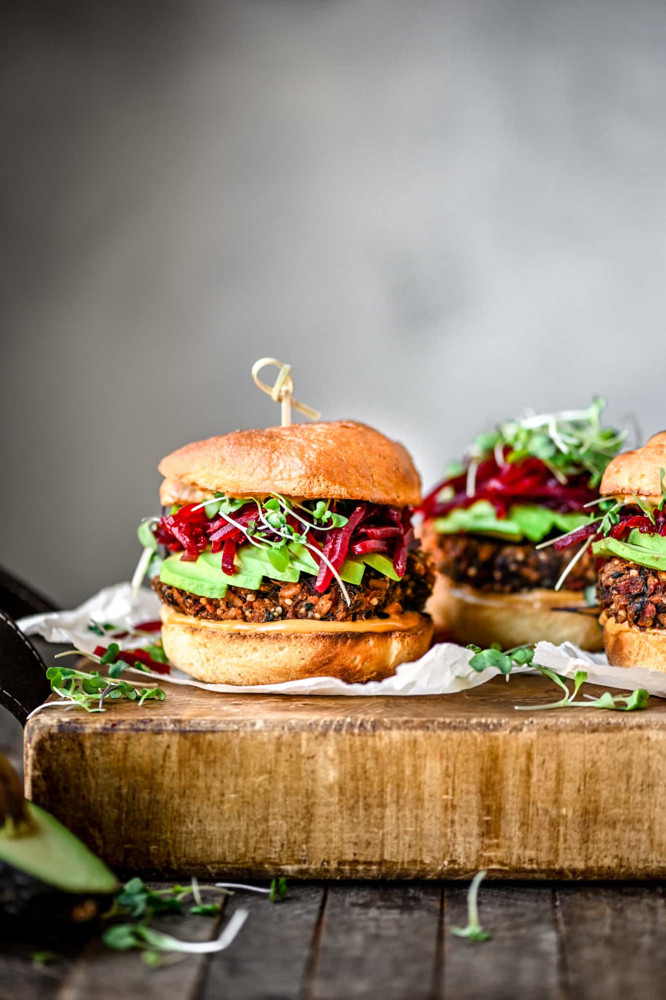 Side view of gluten free veggie burger with smoky shredded beets an avocado