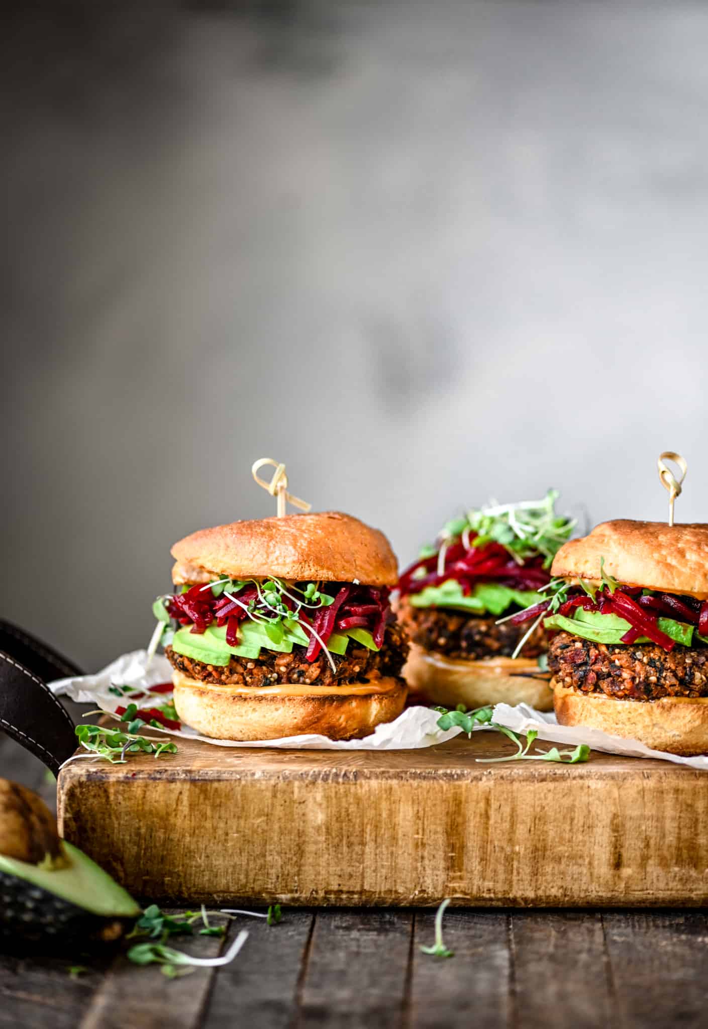 Side view of gluten free veggie burger with smoky shredded beets an avocado