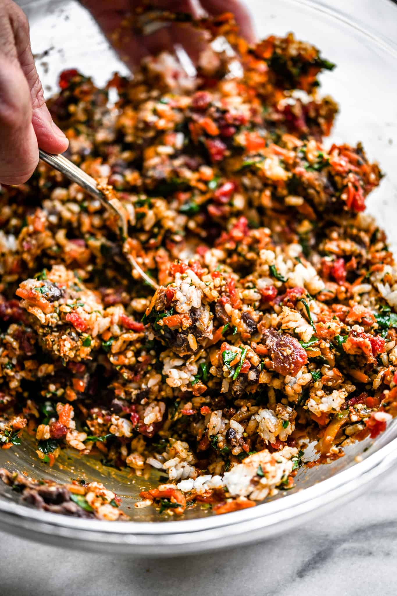 Veggie burger filling being mixed together in a large glass bowl