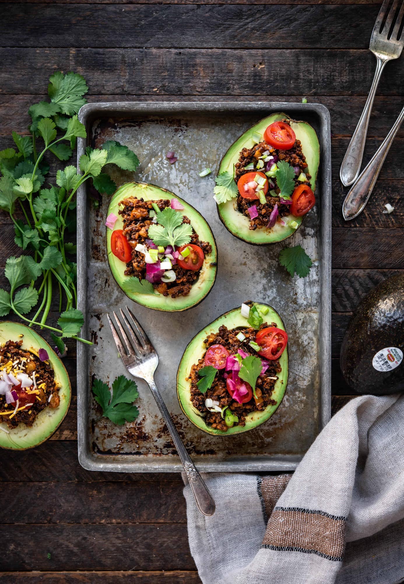 Overhead view of vegan taco stuffed avocados on a sheet pan on wood background