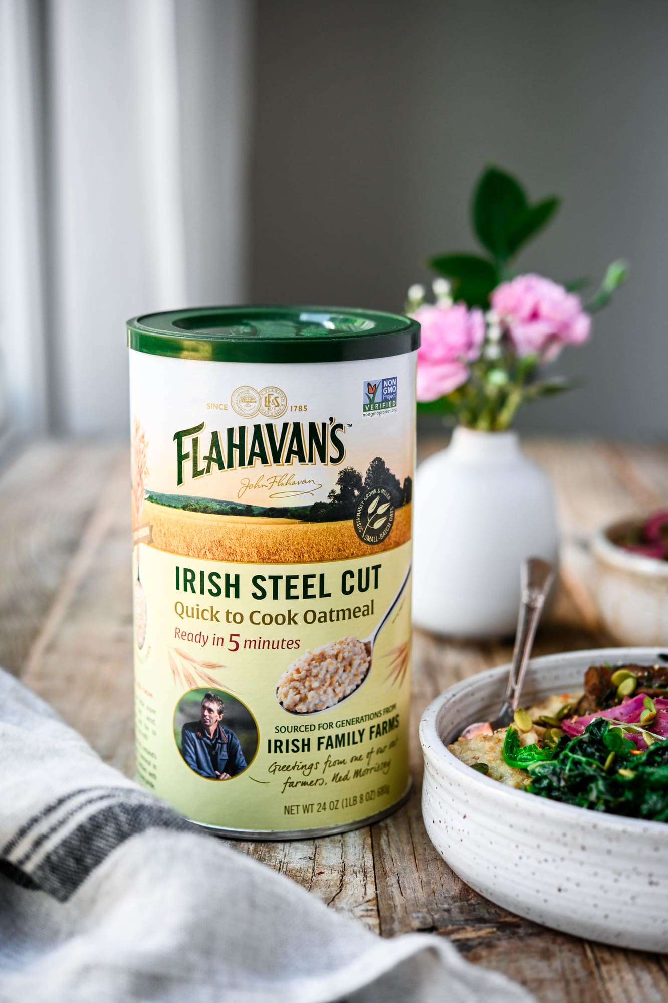 Side view of container of Flahavan's Irish Steel Cut Oatmeal on wood table