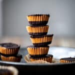 Stack of vegan peanut butter cups on an antique tray with white background