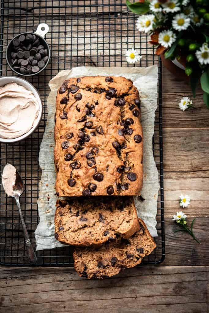 Overhead view of banana bread on a cooling rack and parchment paper