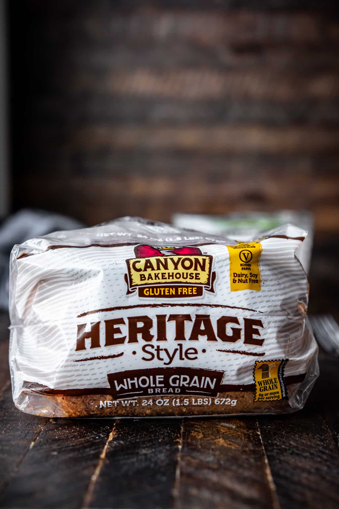 Side view of Canyon Gluten Free Heritage Style Whole Grain Bread on wood background