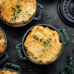 Overhead of vegan lentil shepherd's pie with mashed potatoes in mini Staub cocottes
