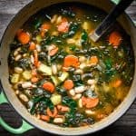 Overhead view of one-pot white bean kale soup in a green stock pot