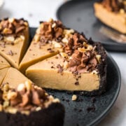 close up view of peanut butter pie with chocolate cookie crust on black plate.