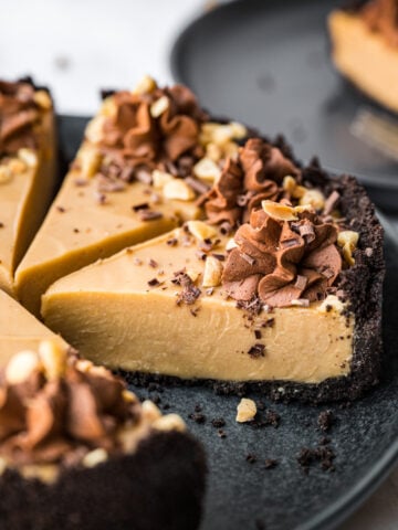 close up view of peanut butter pie with chocolate cookie crust on black plate.