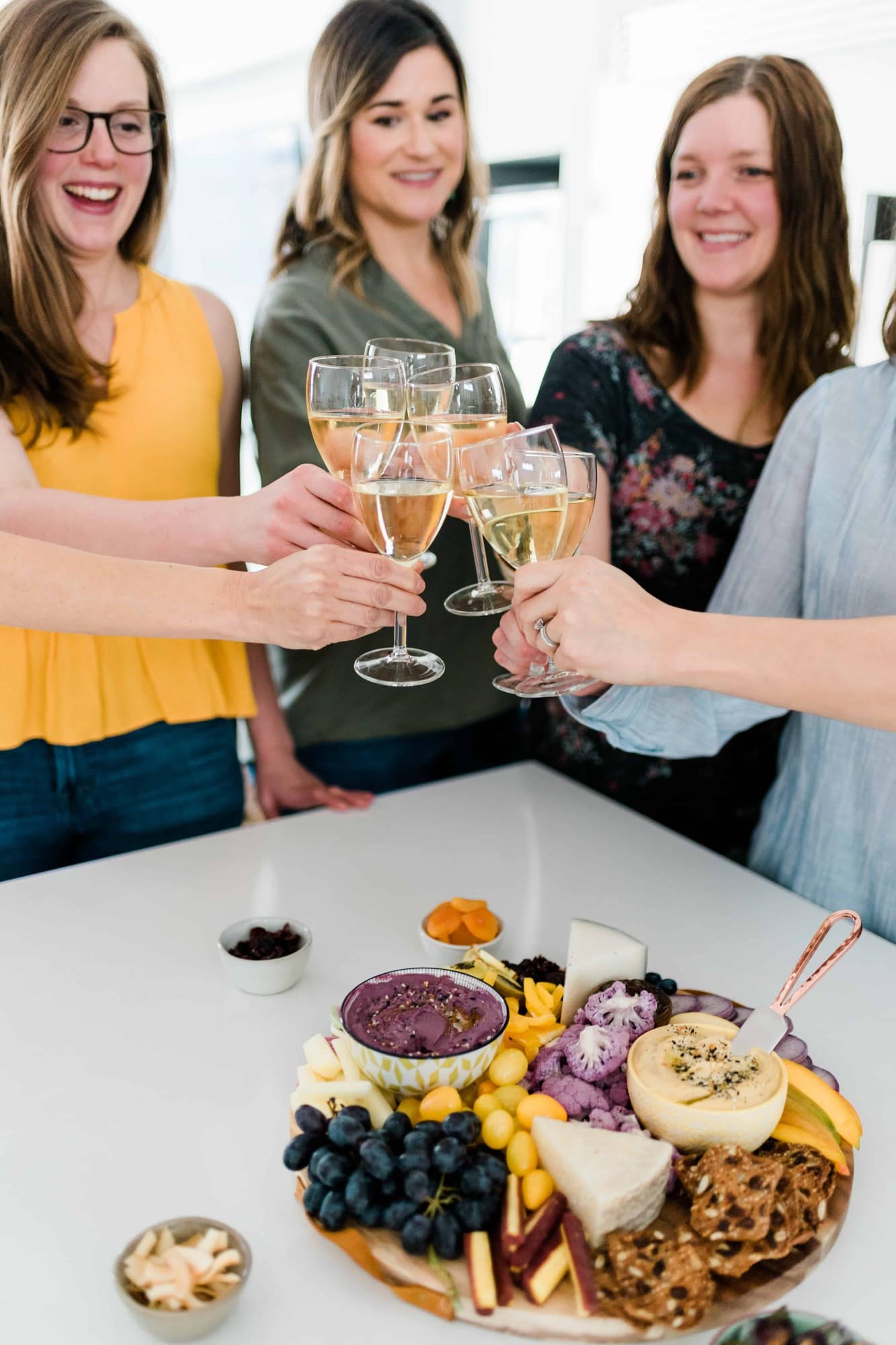 Six women clinking white wine glasses together