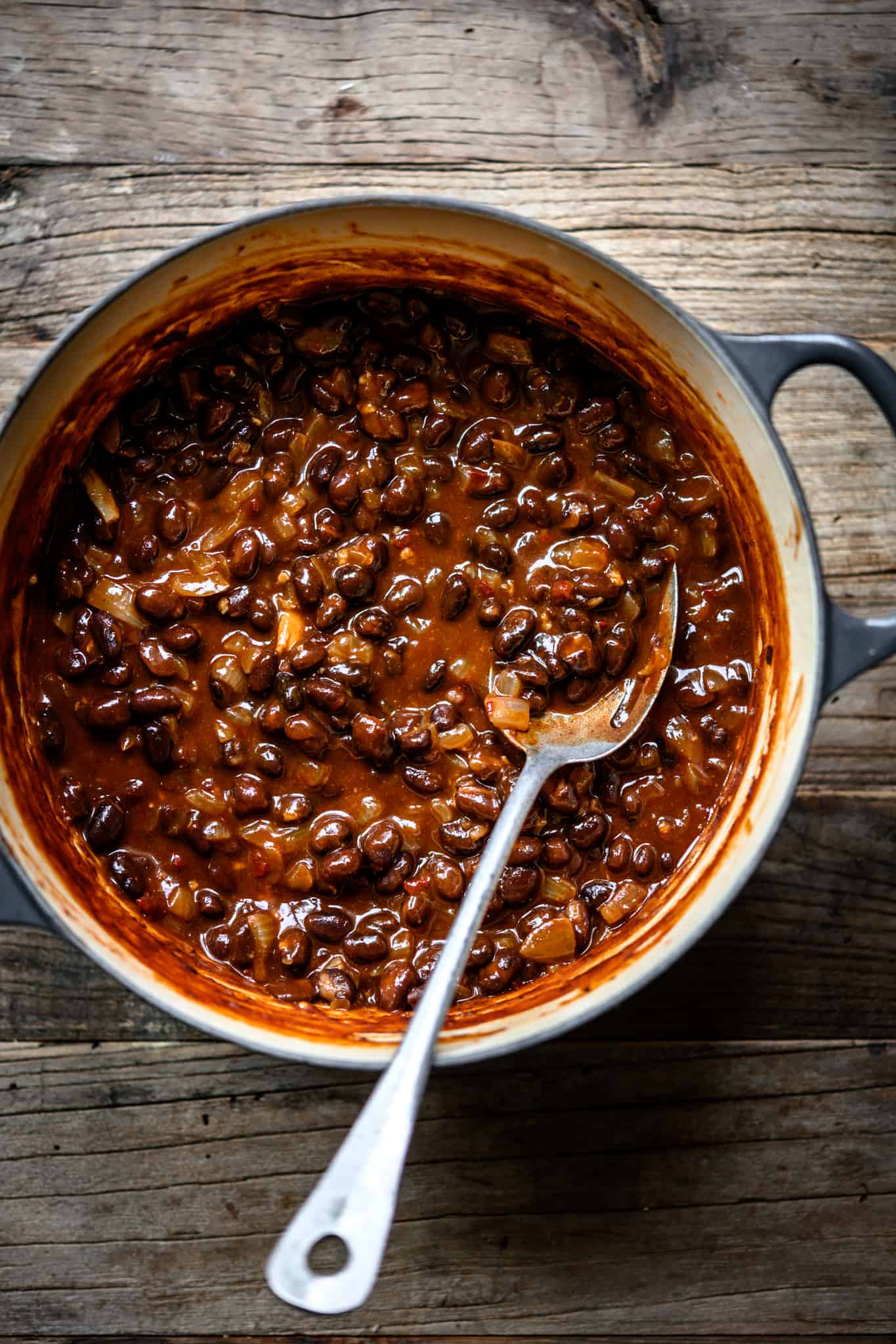 Overhead view of spicy vegan black beans in a large pot