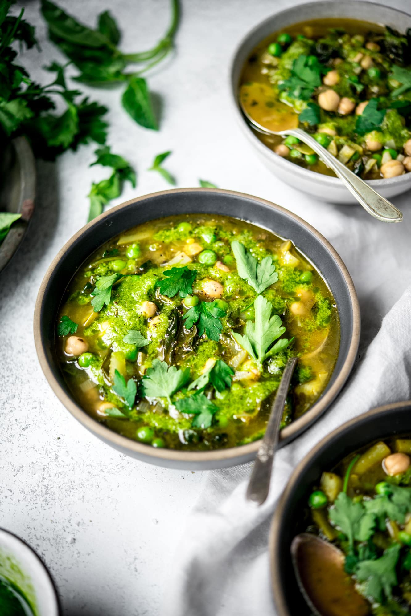 Side view of super green vegetable soup in a bowl with spoon