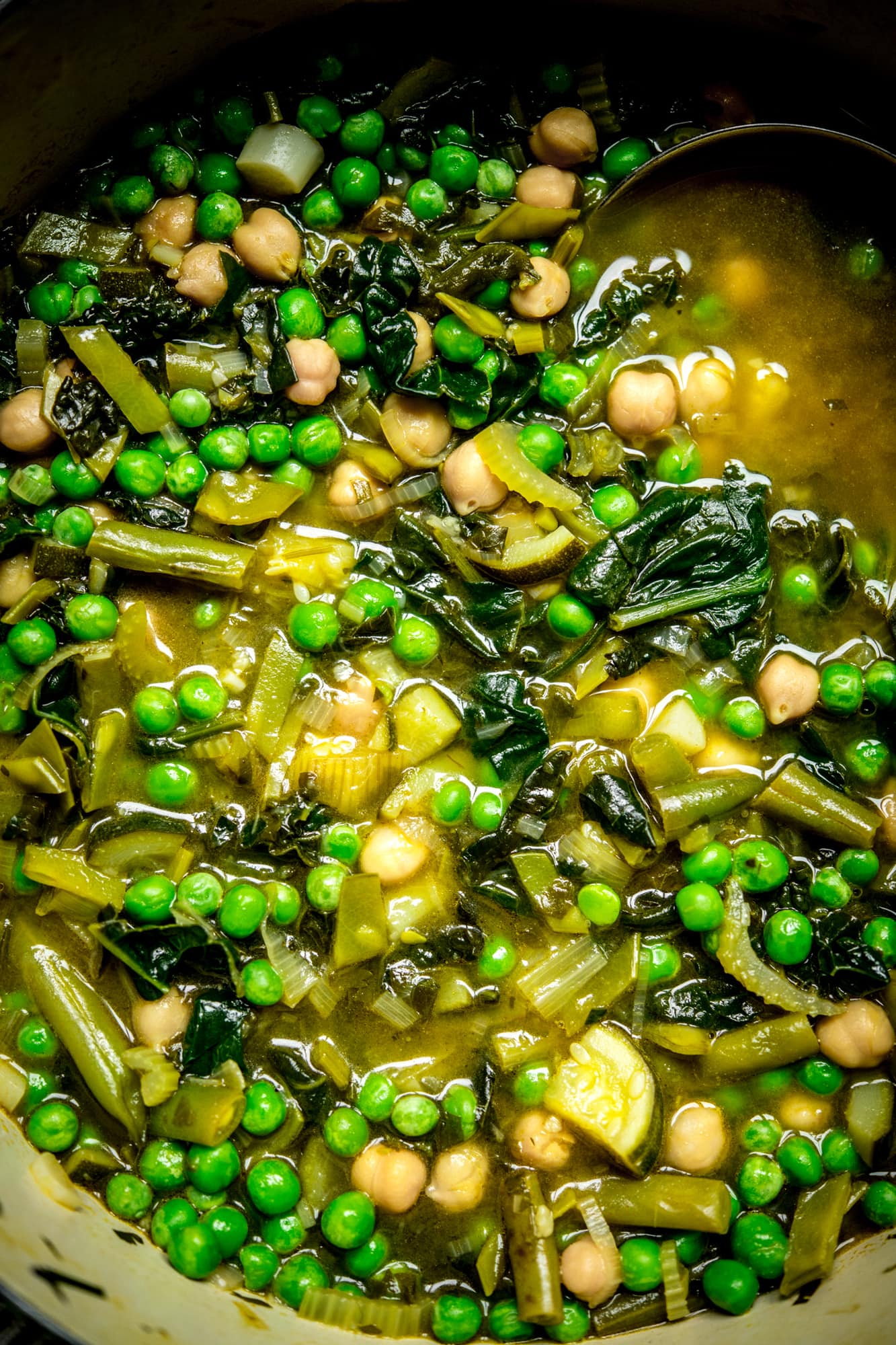 Close up Overhead view of pot of green vegetable soup with green peas