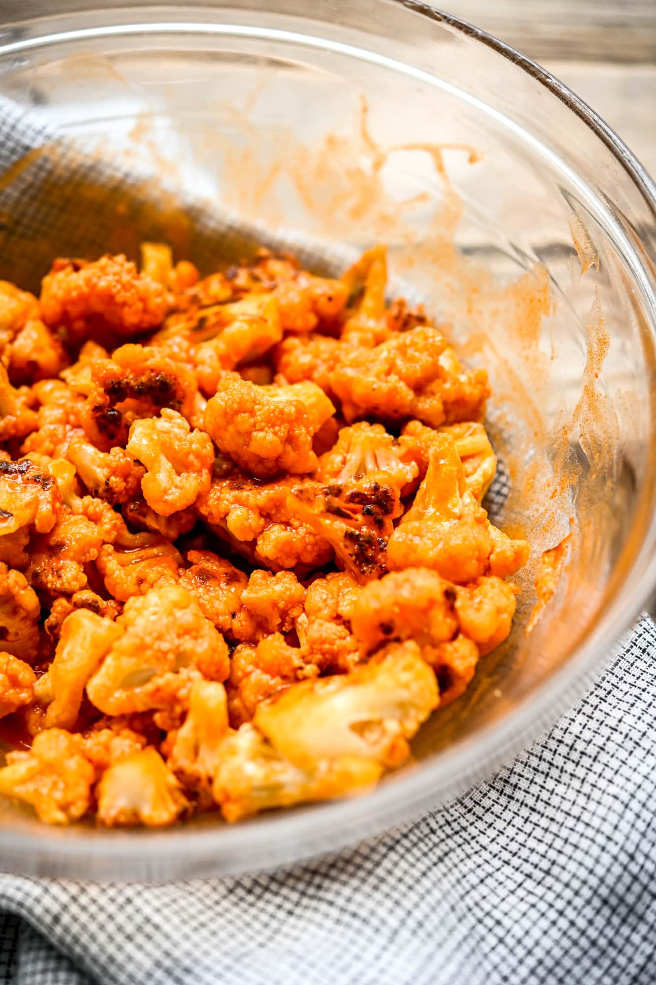 Close up side view of vegan buffalo cauliflower in a glass bowl
