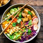 Overhead view of bowl with crispy tofu and rice noodles and sesame miso dressing for meal prep