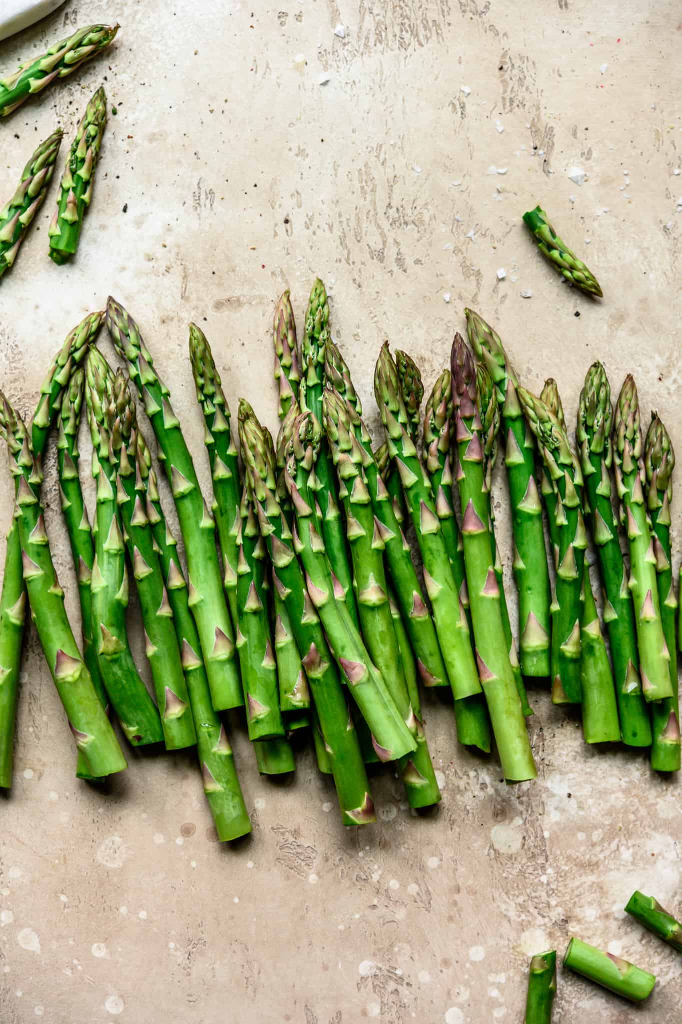 Overhead view of beautiful food photography of asparagus spears on a light tan background