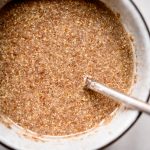 Overhead view of water and flax meal in bowl to make a vegan flax egg