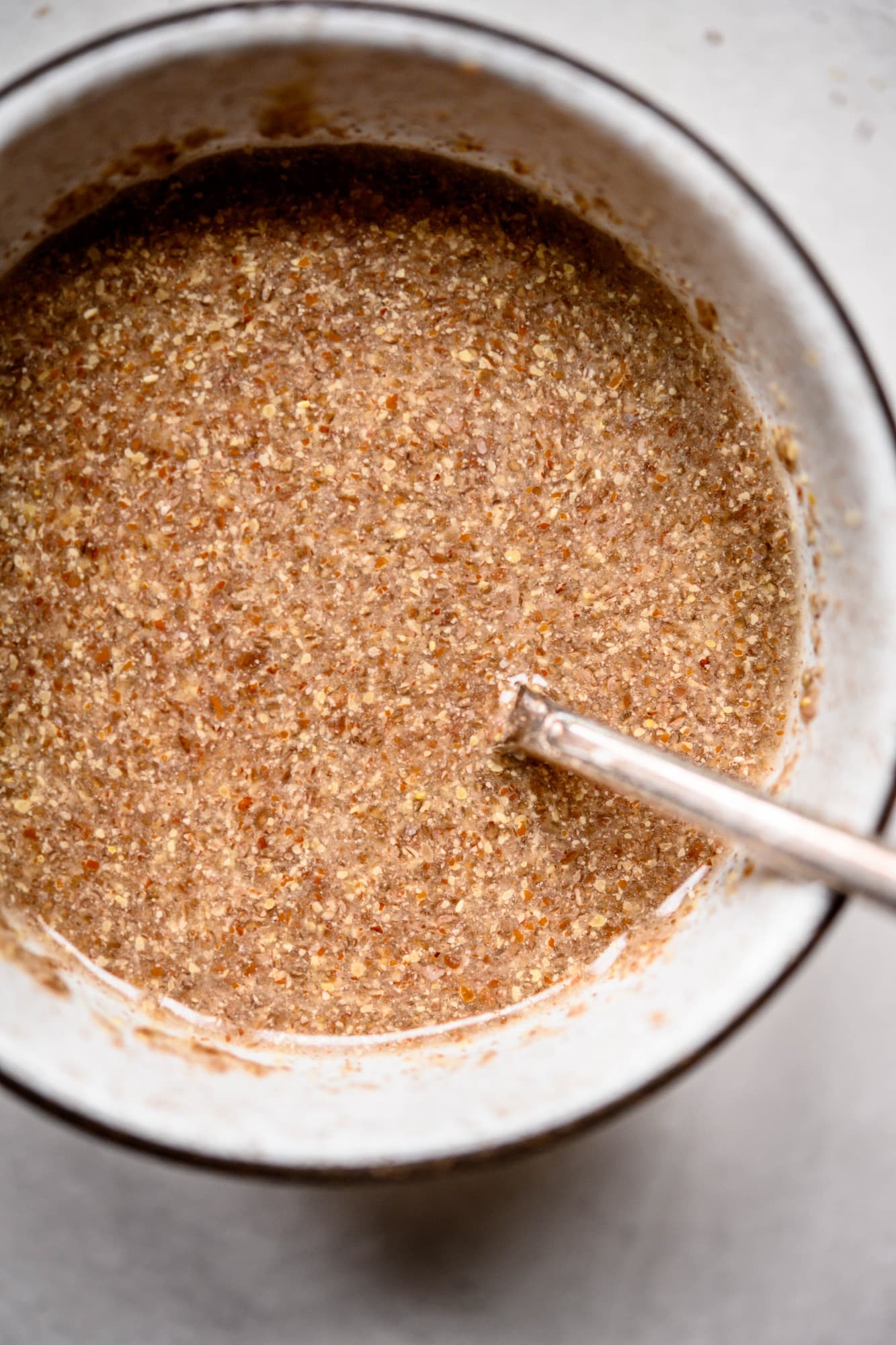 Overhead view of water and flax meal in bowl to make a vegan flax egg