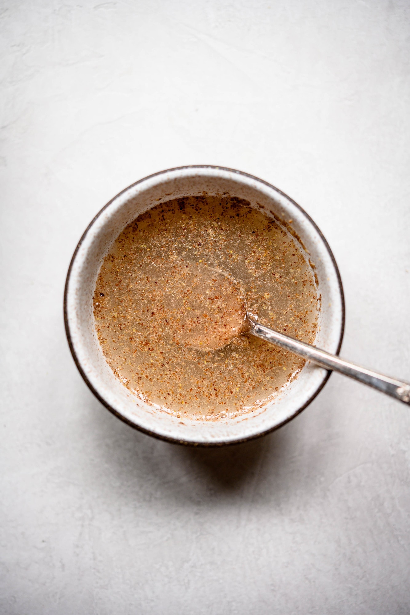 Overhead view of water and flax meal in bowl to make a vegan flax egg