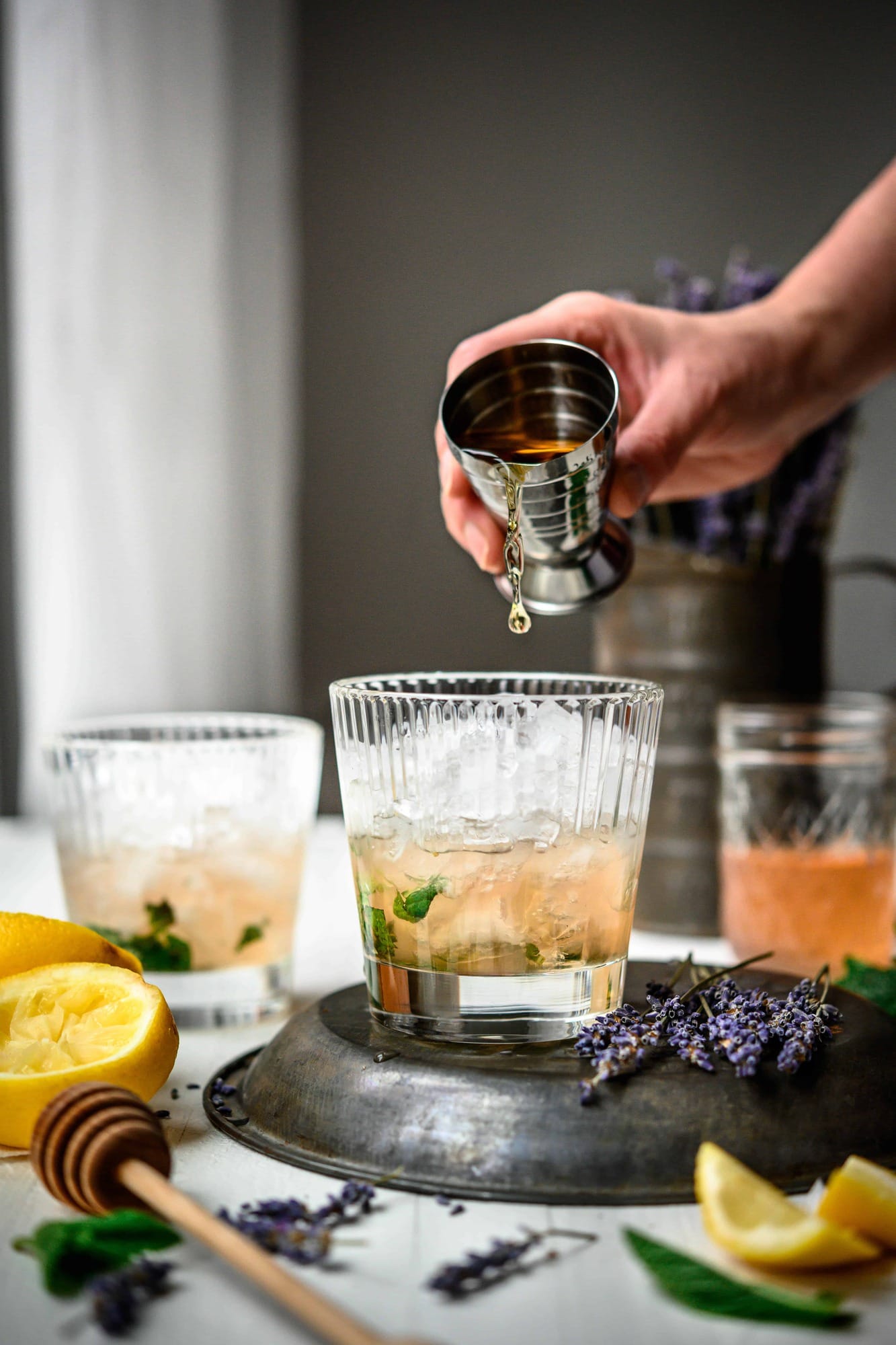 Pouring bourbon into cocktail glass, captured right before it hits the glass