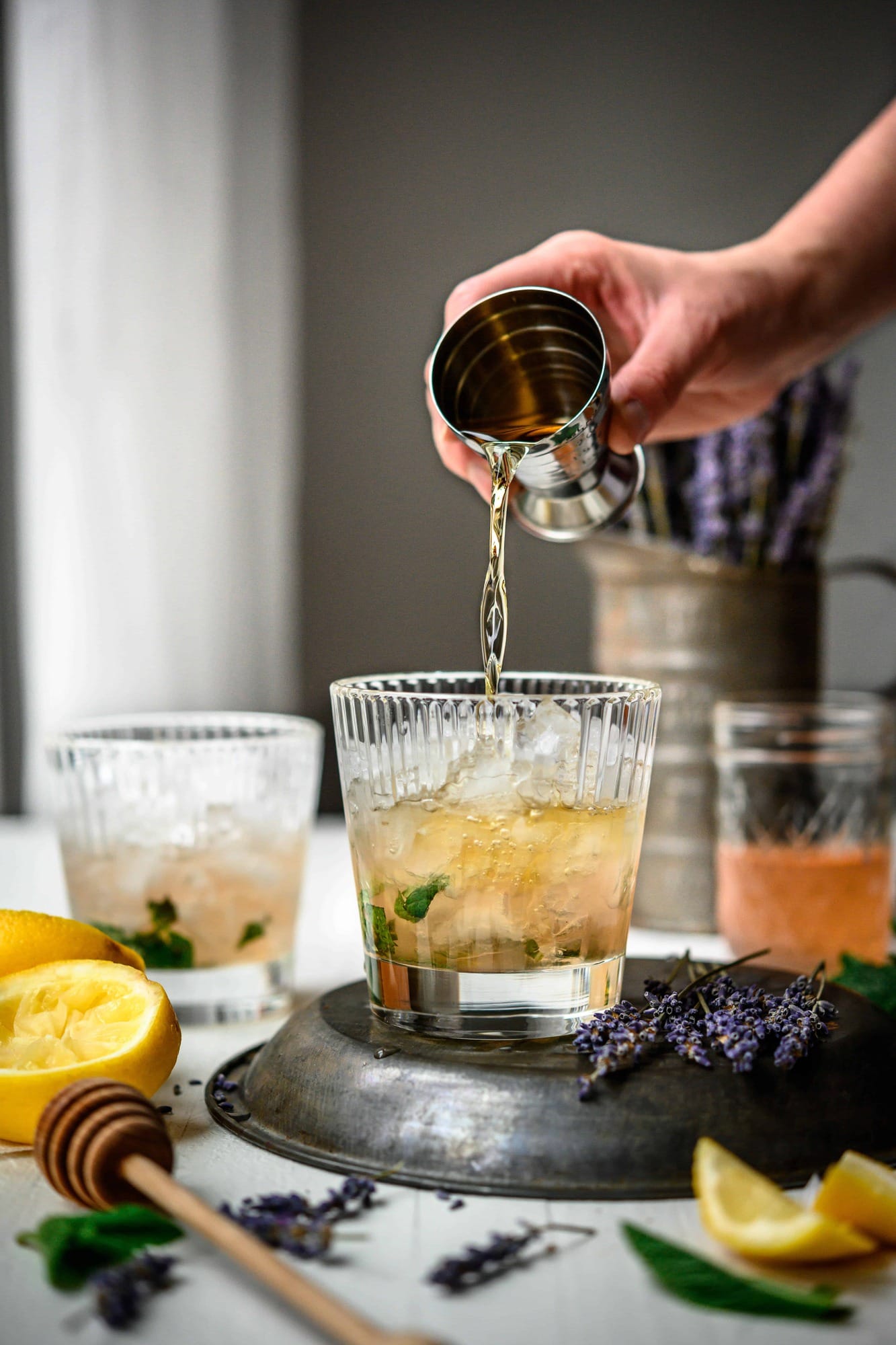 Side view of pouring bourbon into homemade mint julep