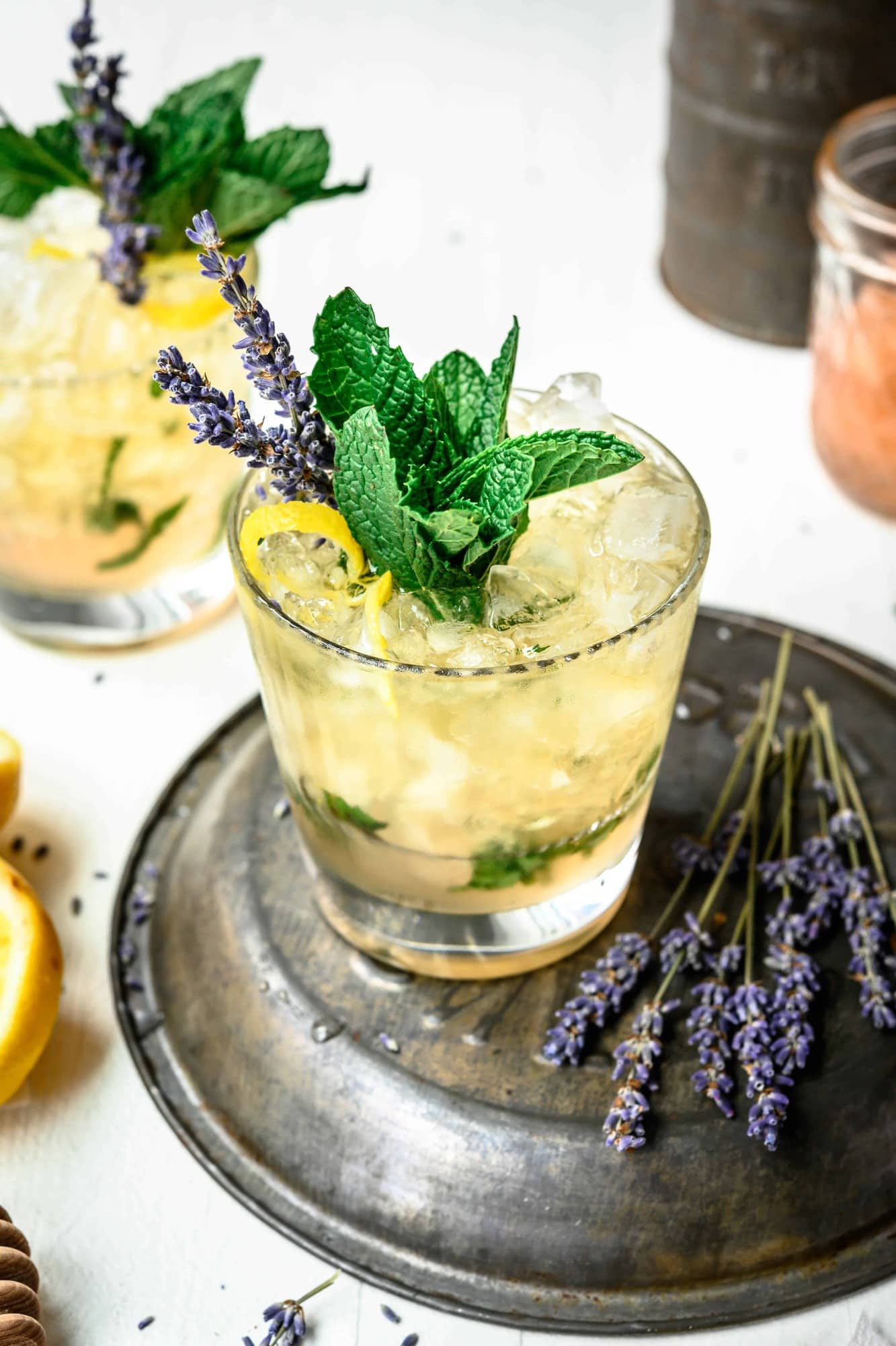 High side view of lemon lavender mint julep garnished with fresh mint, lavender and lemon peel