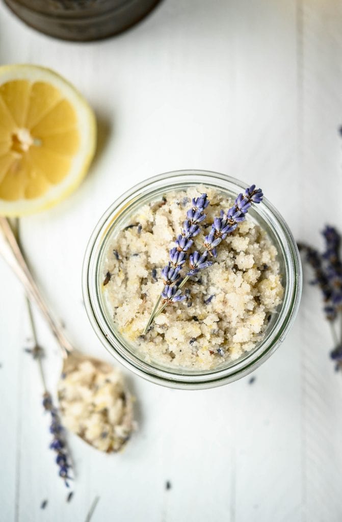 Overhead view of lavender lemon sugar scrub in glass jar with dried lavender stems on top