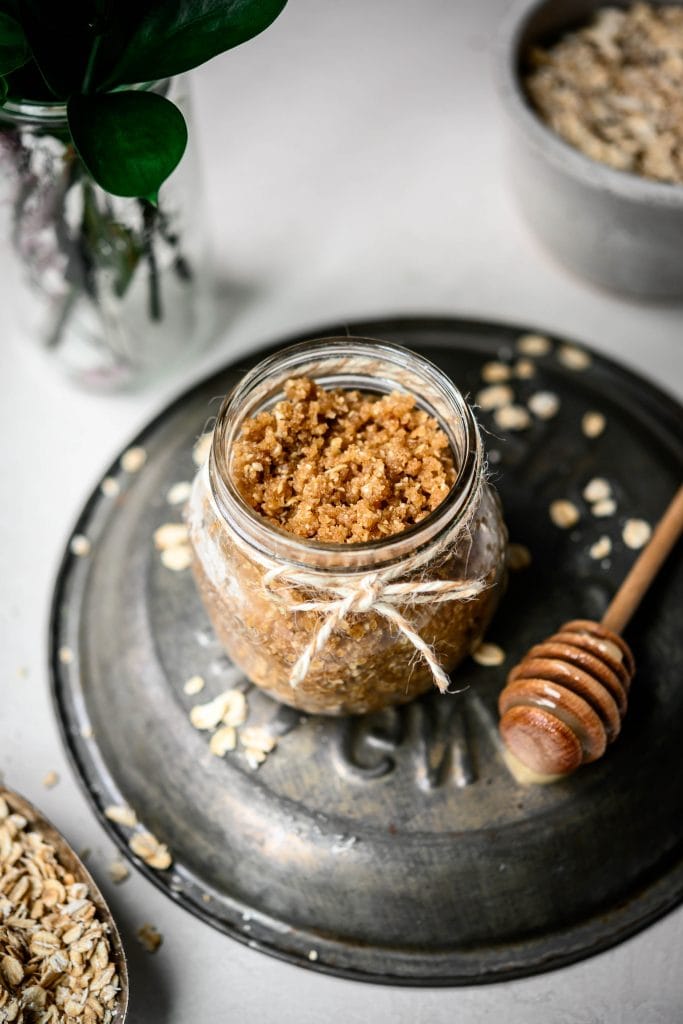 High side view of oatmeal cookie body scrub in a small glass jar