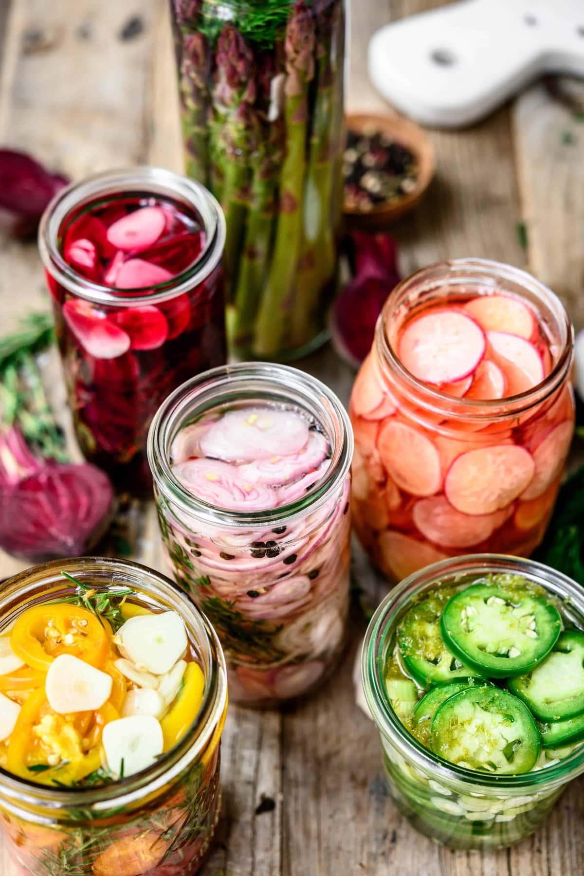 Side view of homemade quick pickles in glass jars on wood table