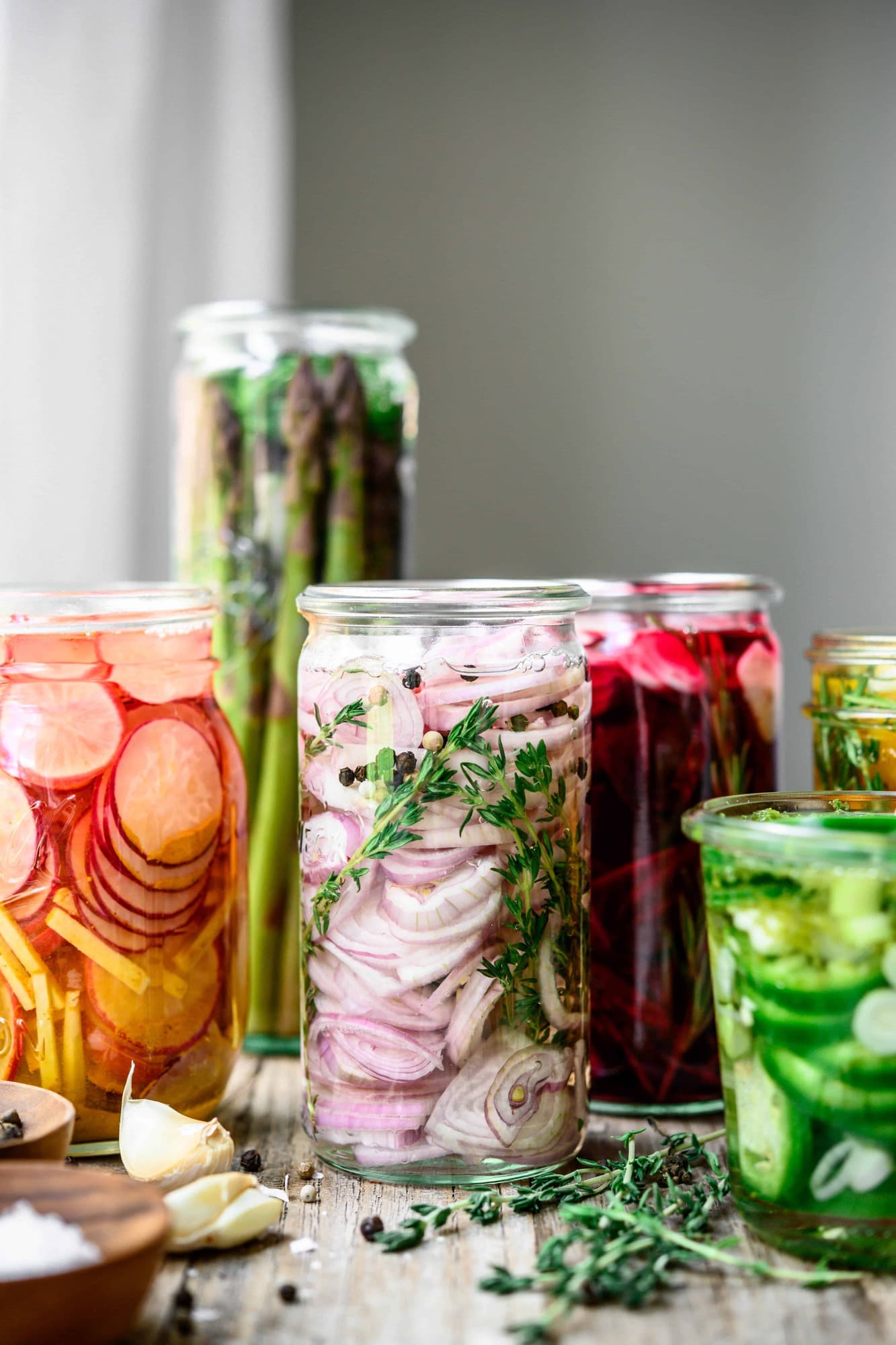 Side view of homemade quick pickled shallots in glass jar on wood table