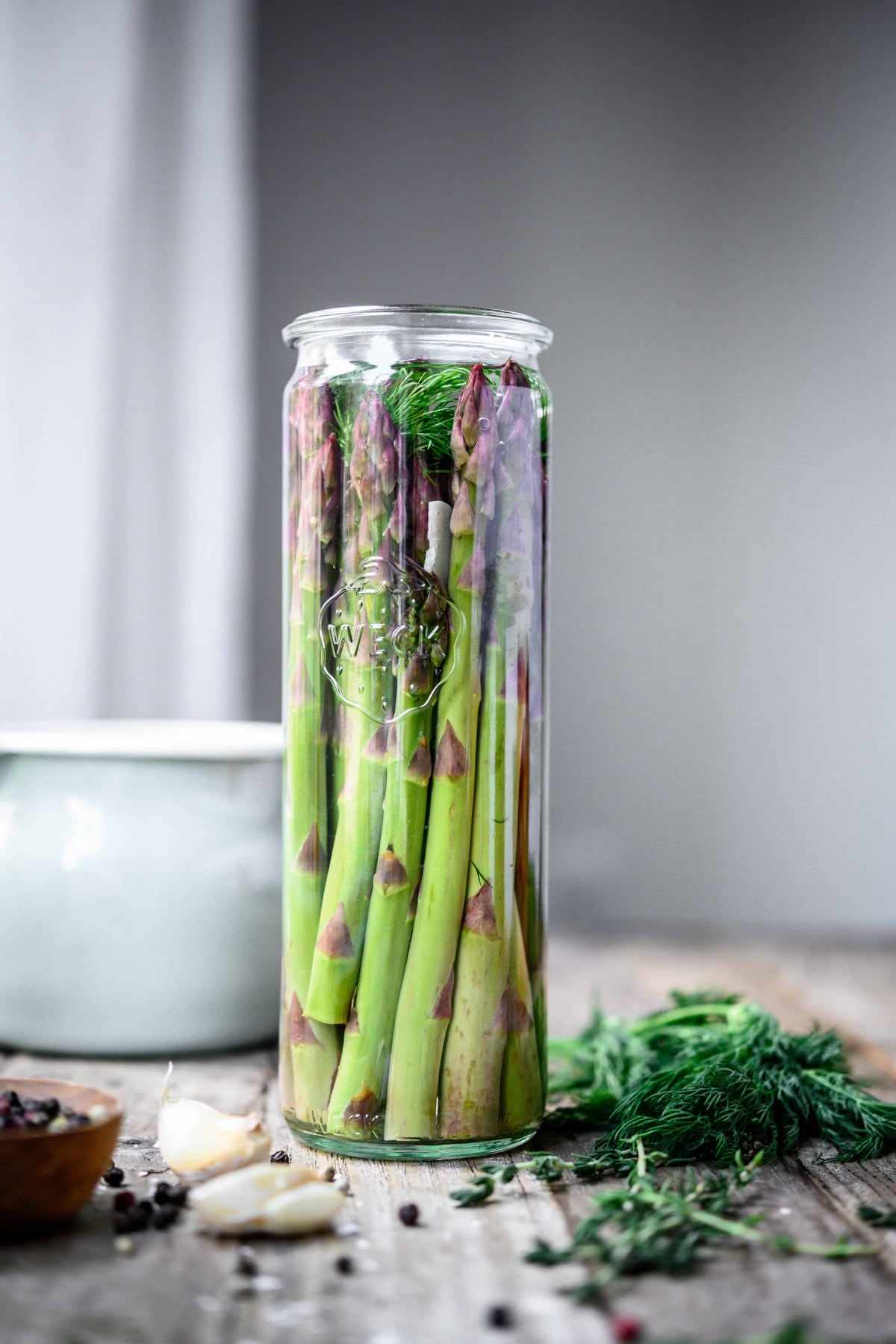 Side view of tall glass jar of dill pickled asparagus