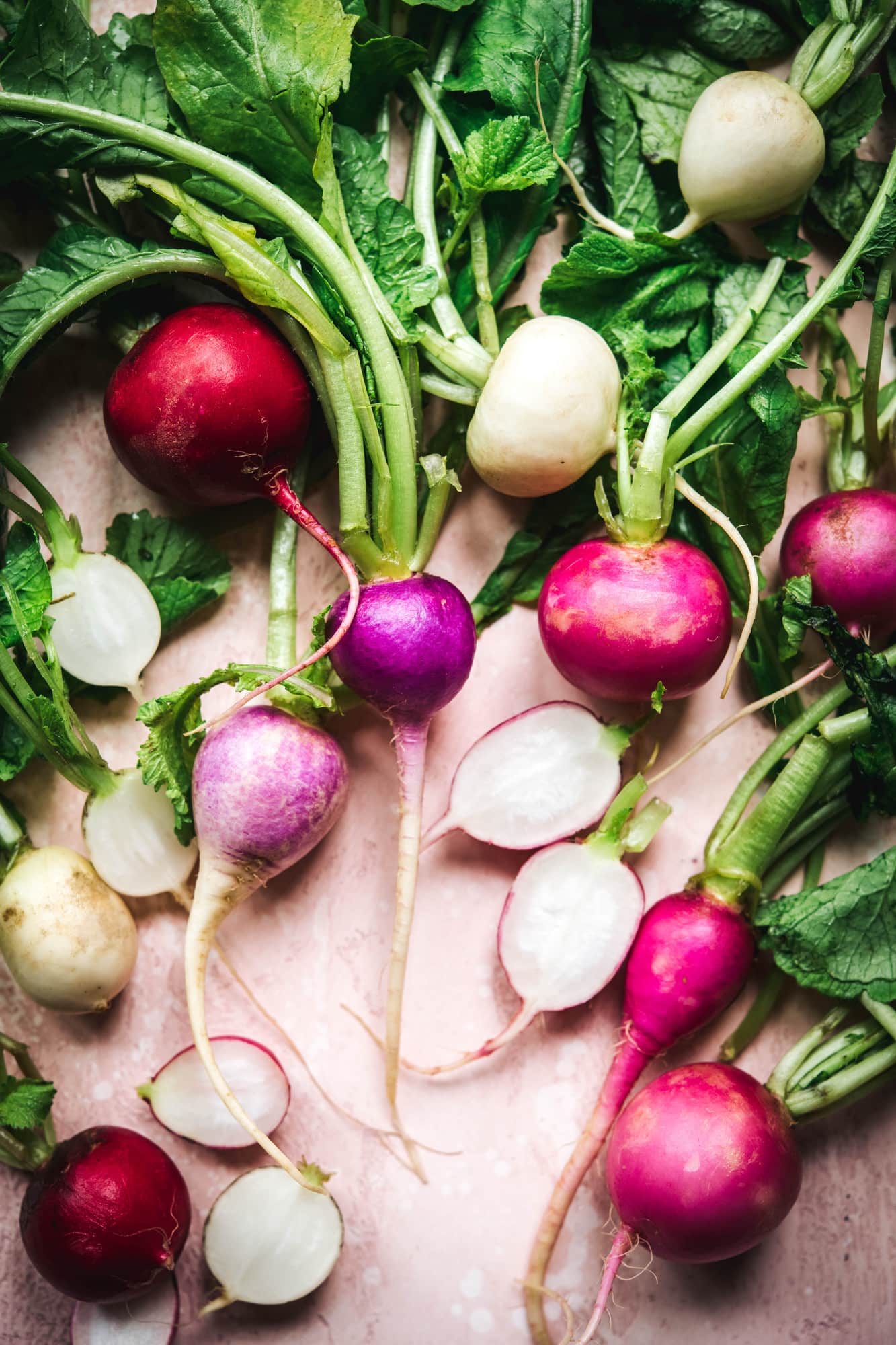 overhead view of fresh radishes on pink backdrop