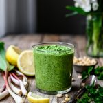 Side view of vegan ramp pesto in glass jar on wood table