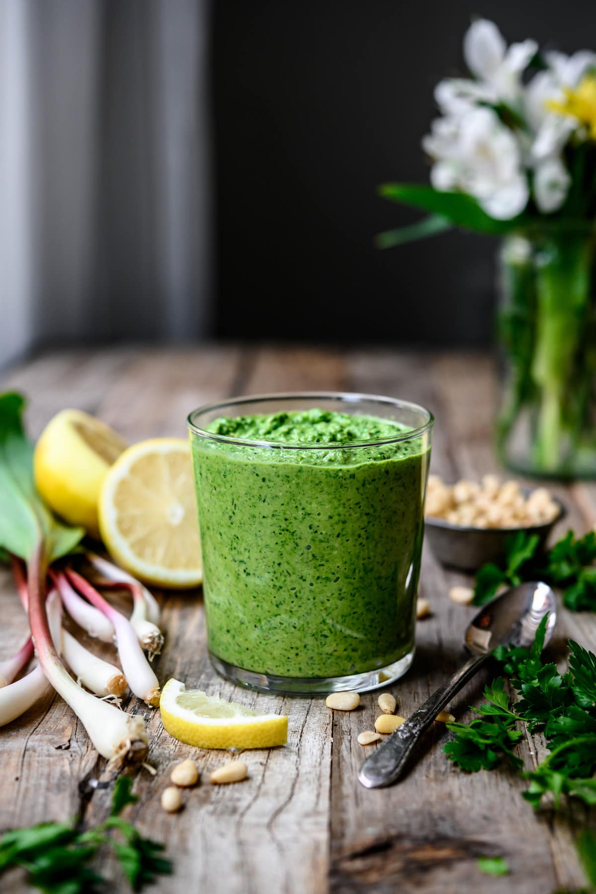 Side view of vegan ramp pesto in glass jar on wood table