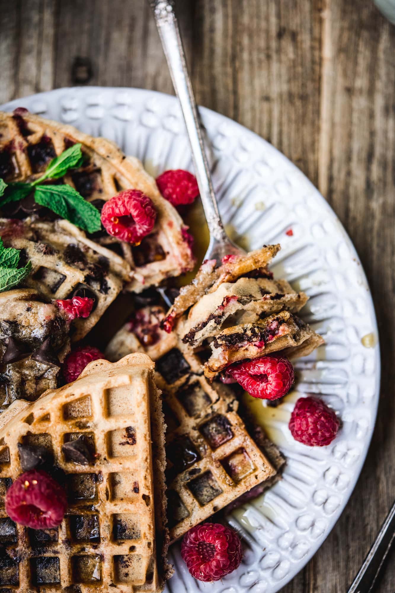 side view of raspberry chocolate chip waffles on plate