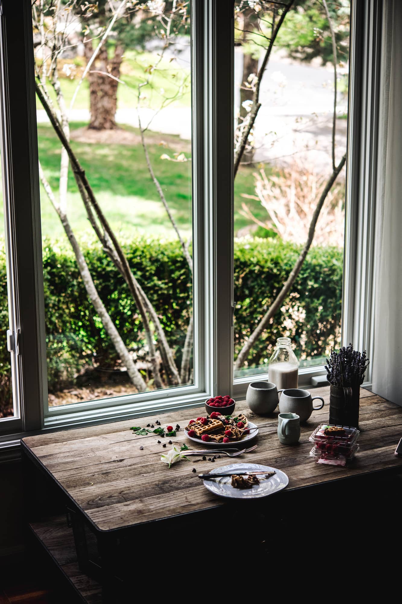 Side view of food photography setup with a wood table next to a large window