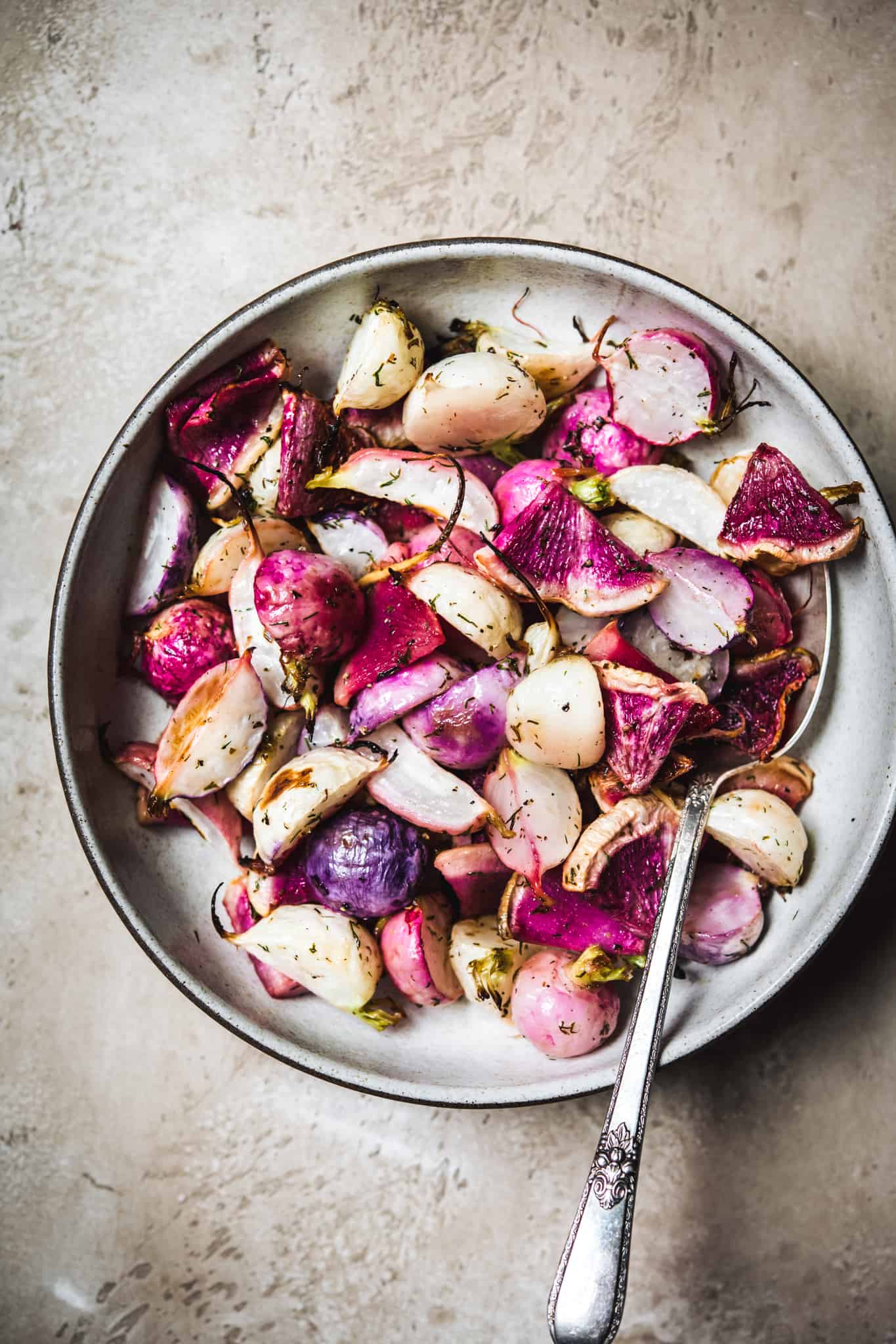 overhead view of roasted pink radishes in bowl