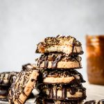 Side view of stack of gluten free vegan Samoa cookies on white background