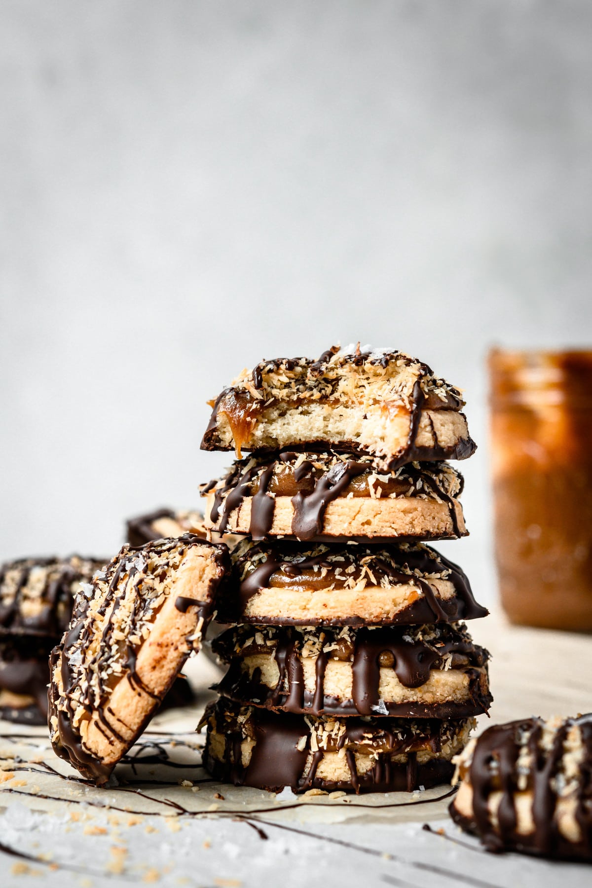 Side view of stack of gluten free vegan Samoa cookies on white background