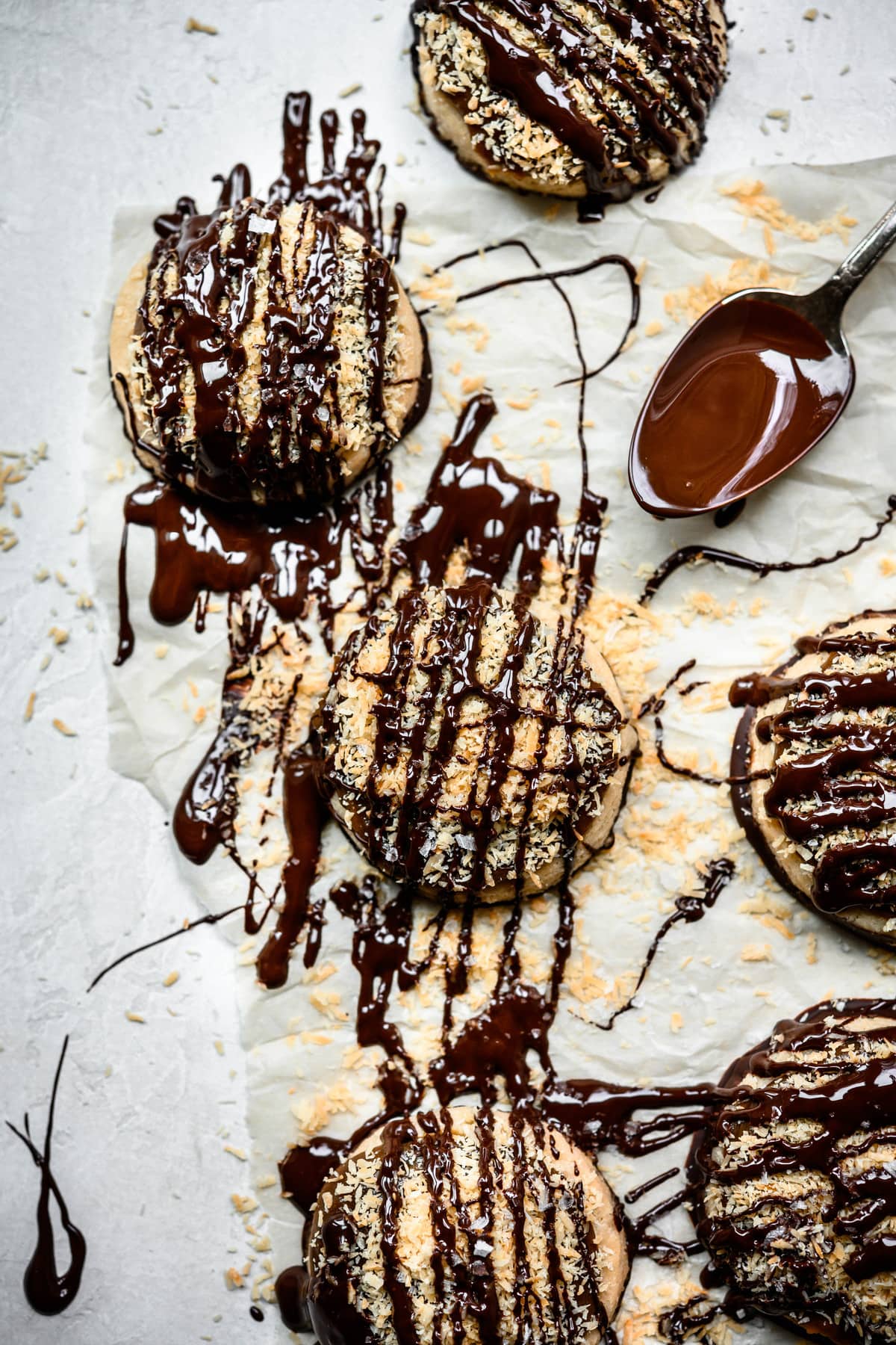Overhead view of gluten free vegan Samoa cookies on parchment paper with dark chocolate drizzle
