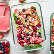 Overhead view of berry avocado salad in a glass container.