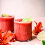 Side view of frozen jalapeño watermelon margaritas on pink background