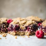 vegan four berry pie bars with a bite taken out