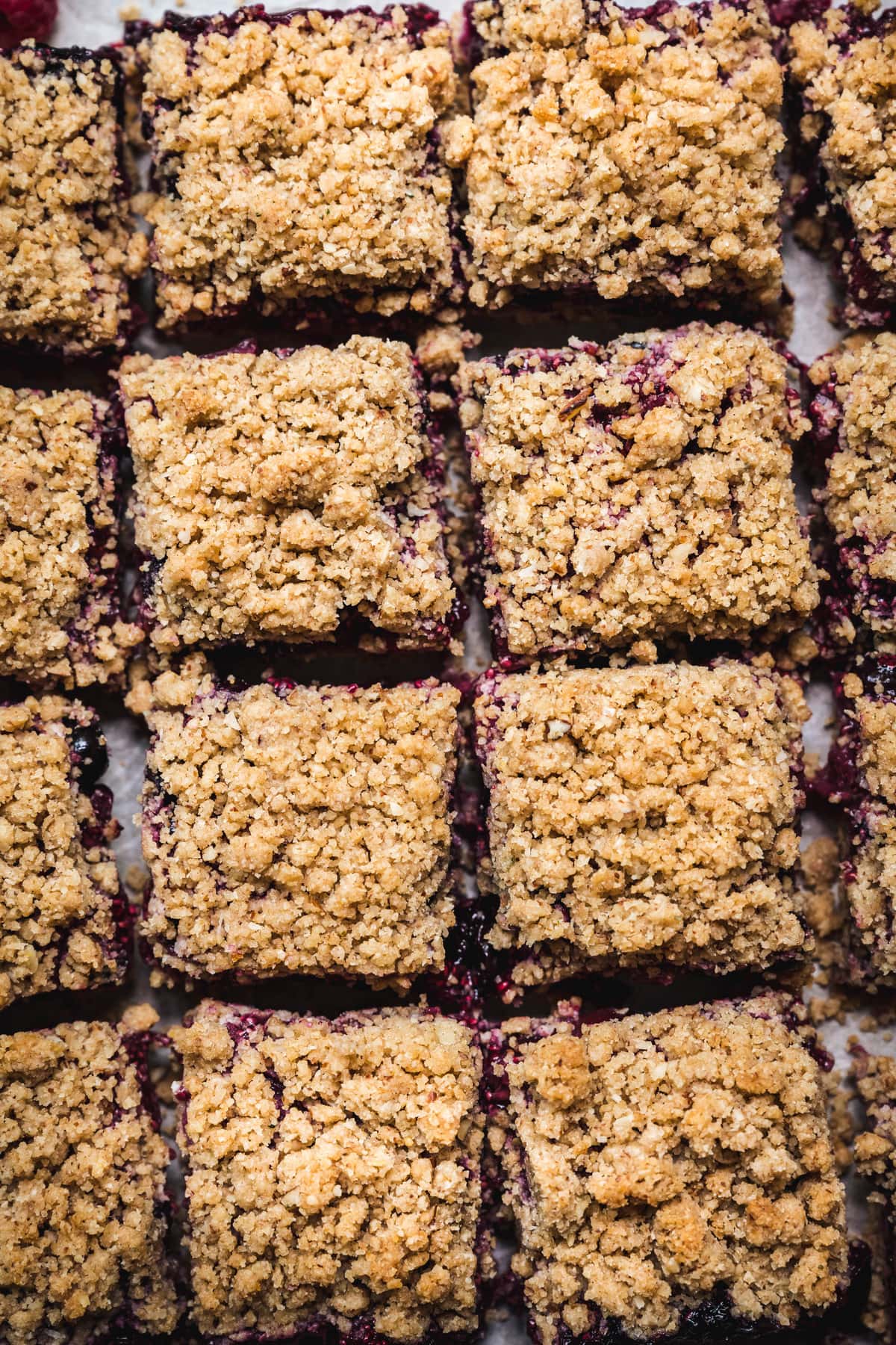 overhead of vegan four berry pie bars cut into squares on a baking sheet