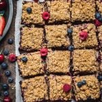 overhead of vegan four berry pie bars cut into squares on a baking sheet